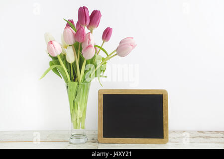 Tulip with blank picture frame on white wooden table Stock Photo