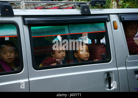 Little school children peaking out of window of van, Yuksom, Sikkim, Tibet Stock Photo