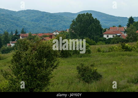 Scene with mountain glade, forest and residential district of bulgarian village Plana, Plana   mountain, Bulgaria Stock Photo