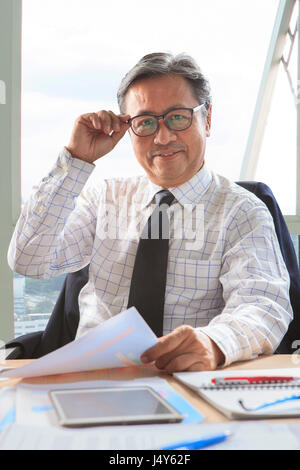 asian senior business man relaxing on working table Stock Photo