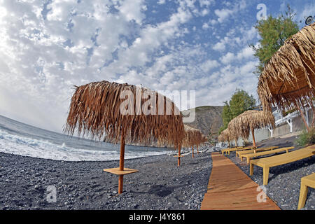 Parsols and sunbeds on  Kamari Beach Kamari, Santorini, Greece Stock Photo