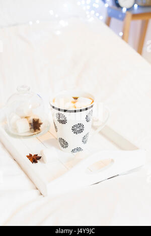 Breakfast in bed - tray with cup of coffee and marshmallows, cozy hygge home style Stock Photo