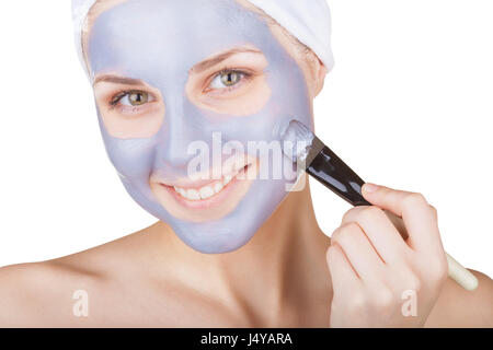 Beauty woman getting facial mask isolated on white background Stock Photo