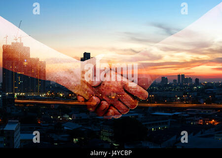 Industry 4.0 internet of things and digital disruption concept. Double exposure of Shaking hands of male people and robot circuit electronic hand with Stock Photo