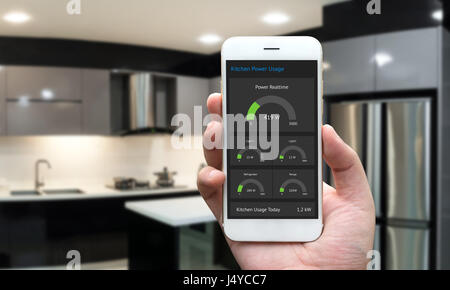 Internet of things , iot , smart home , kitchen and network connect concept. Human hand holding white phone and smart home application to count power  Stock Photo