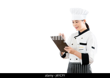 smiling asian woman chef using digital tablet to check menu food order. isolated on white background. profession and industry job concept. Stock Photo