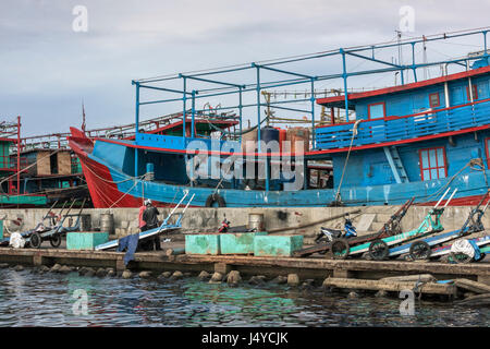 Harbour scene with fish carts, fish boxes and fishing boats, Pasar Akan Harbour, Jakarta, Indonesia Stock Photo