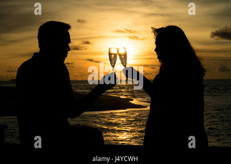 Happy and romantic couple enjoying sunset on beautiful tropical beach ...