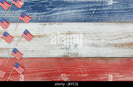 Flay lay view of USA mini flags on rustic wooden boards painted in red, white and blues colors. Stock Photo