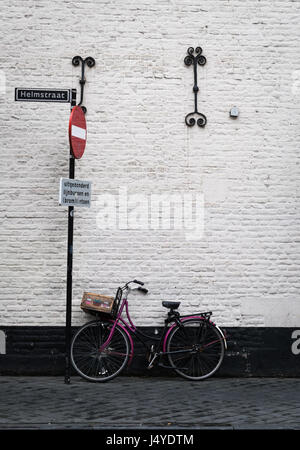 Bicycle propped against an old wall in the town of Maastricht, Netherlands (Sign 'No Entry except buses, bicycles and scooters') Stock Photo