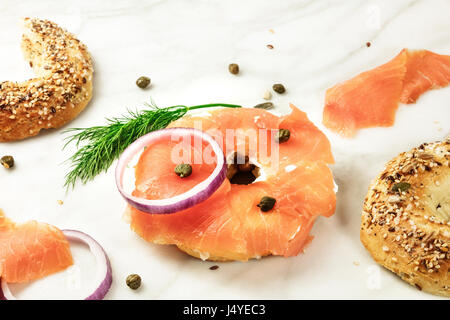 Making lox bagels, on white marble background with copyspace Stock Photo