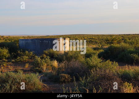 A small farm dam in the sparse vegetation of the Great Karoo natural region in South Africa Stock Photo