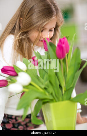 little cute girl smells bouquet of tulips Stock Photo