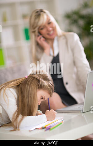 Young cute girl playing while her mom working at home Stock Photo