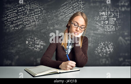 Thinking  student sitting at a desk and working math homework Stock Photo