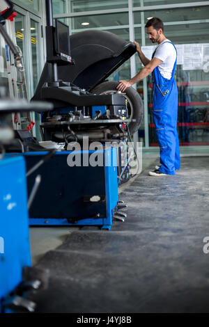 mechanic balancing  car wheel on balancer Stock Photo