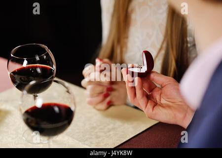 guy doing the girl proposal in restaurant. man gives a woman an  Stock Photo