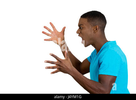 Closeup side view profile portrait angry upset young man worker business employee fists in air open mouth yelling screaming isolated white background. Stock Photo