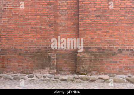 Grunge red brick wall and stone pavement . Urban background Stock Photo