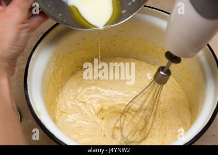 girl kneads the dough with a mixer Stock Photo
