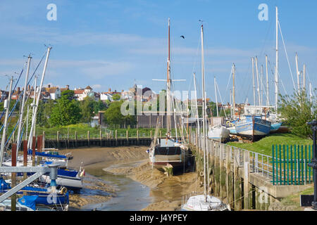 Boats resting on the mud on the tidal River Brede creek, by the boat yard at Rye, Harbour Road, East Sussex, England, United Kingdom, UK, Britain, GB Stock Photo