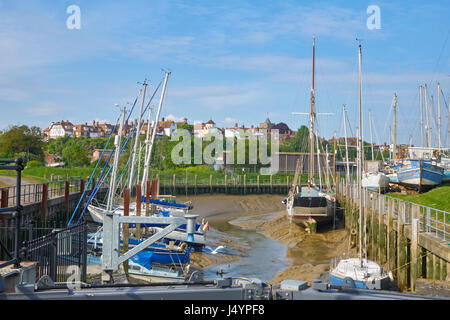 Boats resting on the mud on the tidal River Brede creek, by the boat yard at Rye, Harbour Road, East Sussex, England, United Kingdom, UK, Britain, GB Stock Photo