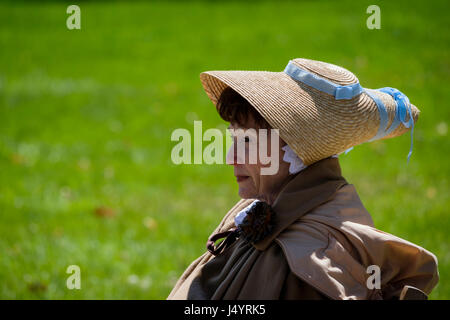 Battle of Longwoods of 1812 reenactment, middle aged woman wearing a bergère hat, straw hat with blue ribbon, contemplative look, Ontario, Canada. Stock Photo