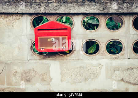 Close up red mail box on cement wall Stock Photo