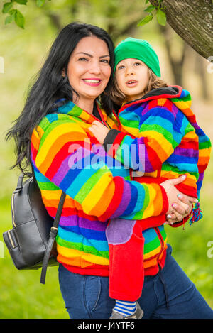 Happy mother and son in park wearing rainbow wool sweaters both of them Stock Photo