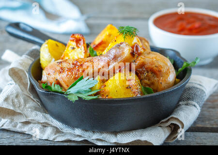 Baked potatoes with chicken in a cast-iron frying pan. Stock Photo