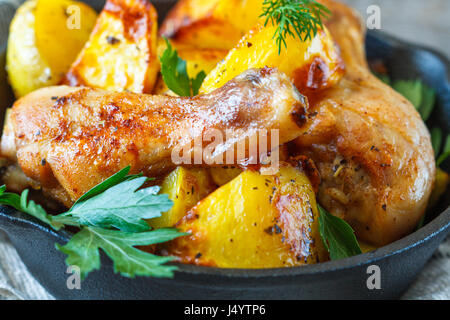 Baked potatoes with chicken in a cast-iron frying pan. Stock Photo