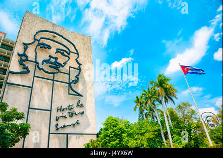 HAVANA - CIRCA JUNE, 2011: Cuban flag flies next to large scale portrait of the revolutionary Che Guevara at the Plaza de la Revolucion. Stock Photo