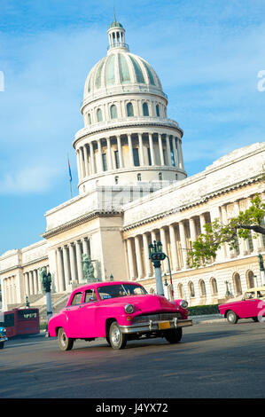 HAVANA - JUNE, 2011: Classic American Cuban taxi car passes in front of the Capitolio building in Central Havana.