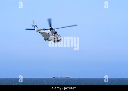 NH90-NFH Caiman NATO Frigate Helicopter of the Belgian Navy flying towards ship on the north Sea during coastal search and rescue mission Stock Photo