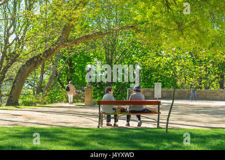 Women talking bench, two elderly women chat on a park bench in the Jardins do Palacio Cristal gardens in the center of Porto, Portugal. Stock Photo