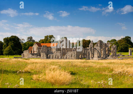 The ruins of Castle Acre Priory from across the water meadow in the late afternoon Stock Photo