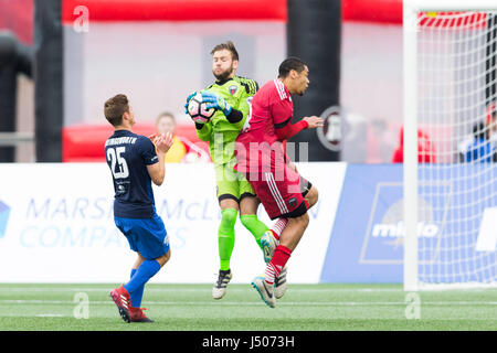 Ottawa, Canada. 13th May, 2017. Ottawa Fury FC goalkeeper Callum Irving (1 ) jumps to make a save between Pittsburgh Riverhounds Marshall Hollingsworth (25) and Fury FC Onua Thomas Obasi (14) during the USL match between Pittsburgh Riverhounds and Ottawa Fury FC at TD Place in Ottawa, Canada. Credit: csm/Alamy Live News Stock Photo