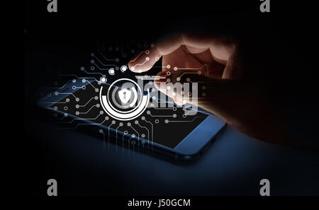 Cyber security network concept. Man Finger using smartphone with Shield lock networking virtual graphic and binary coded screen. Stock Photo