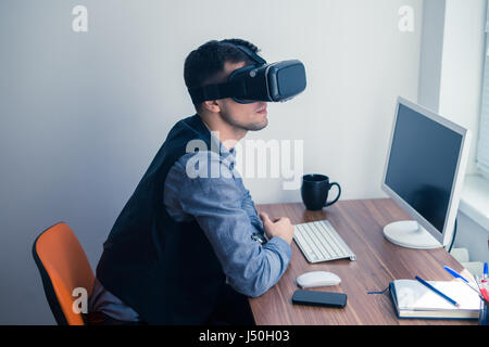 Young businessman in vr glasses looking forward Stock Photo