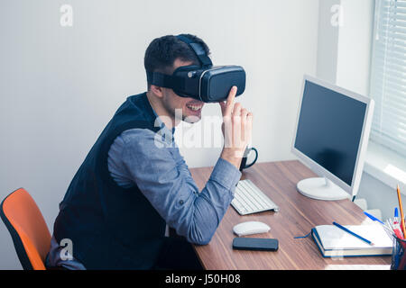 Young businessman putting on vr glasses and smiling Stock Photo