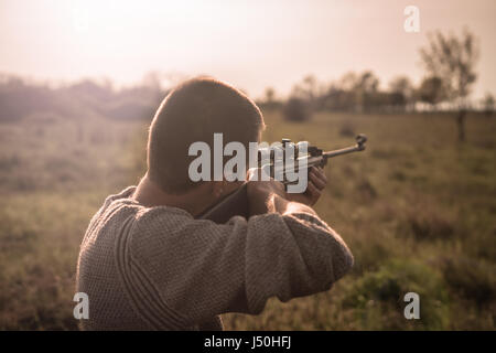 The man takes aim at the target with a sniper rifle. Selective Focus Stock Photo