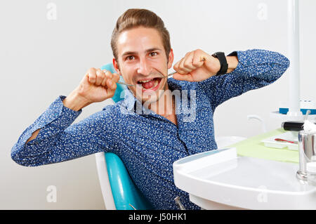 Crazy patient sitting in a dental chair Stock Photo