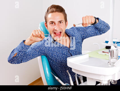 Crazy patient sitting in a dental chair Stock Photo