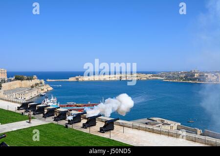 The Noon Gun in the Saluting Battery seen from the Upper Barrakka Gardens with views over the bay towards Fort Rikasoli, Valletta, Malta, Europe. Stock Photo