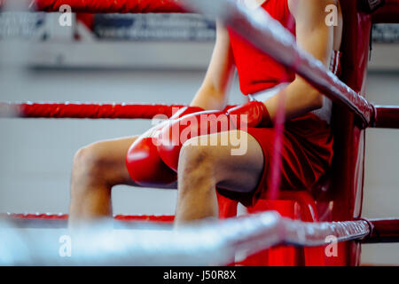 young boxer man in corner boxing ring in break between rounds Stock Photo