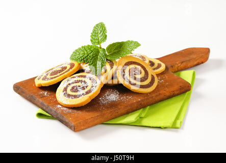 sweet chocolate rolls on wooden cutting board Stock Photo