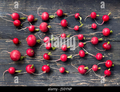 Organic grown red radishes on a dark wooden table Stock Photo