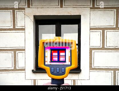 An infrared thermal imager showing building facade and window heat loss. Stock Photo