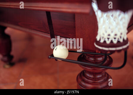 Billiard ball under the pool table in mesh Stock Photo