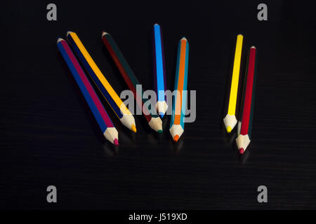 Colored pencils on a dark wooden background, arranged fan-shaped Stock Photo